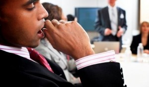 Businessman yawning in meeting, close-up