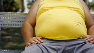mid section view of a man sitting on a bench in a park